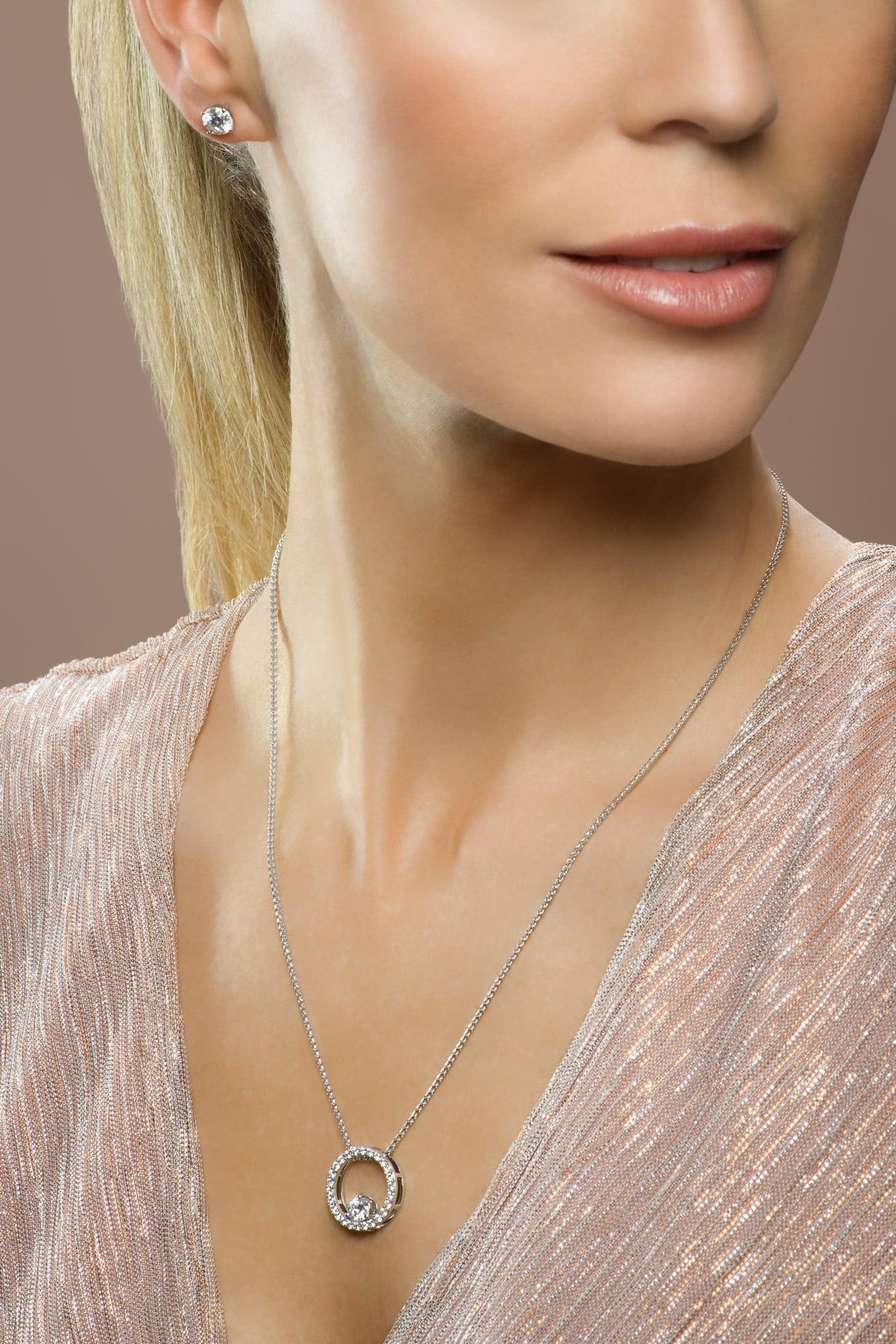 Model wearing diamond stud earring and round necklace and pedant