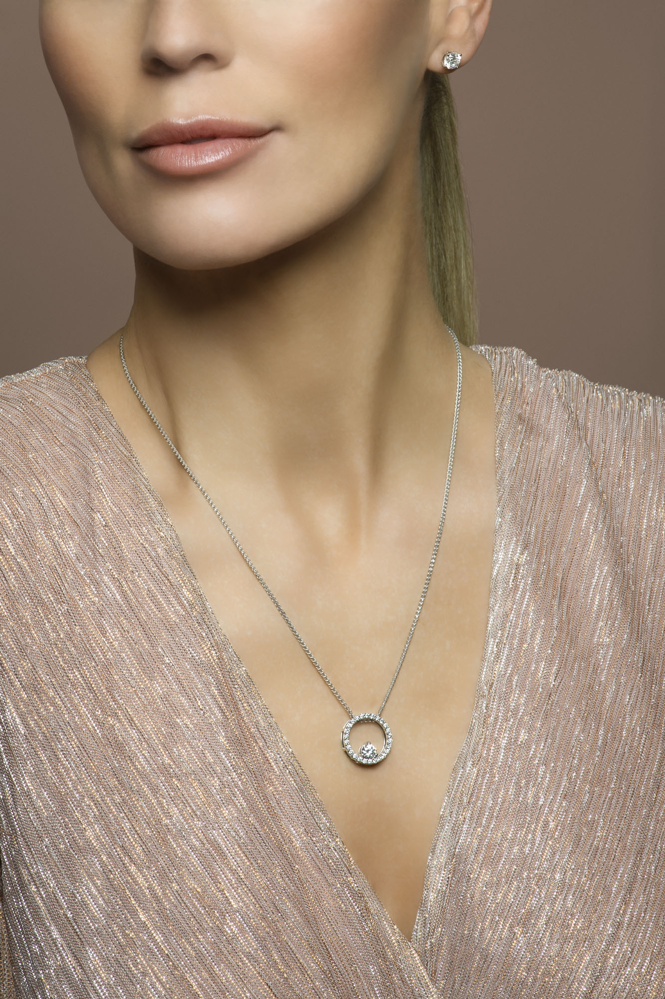 Female model wearing diamond studs and diamond circle pendant